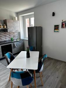 une cuisine avec une table blanche et des chaises bleues dans l'établissement Casa Tribunale, à Asti