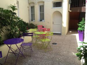 Hôtel Le Chambellan في ديجون: مجموعة من الكراسي الملونة والطاولات على الفناء
