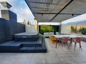 un patio con parrilla, mesa y sillas en Spectacular Apartament in La Dehesa with Private Rooftop, en Santiago