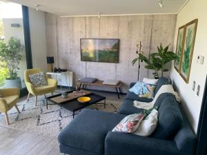 sala de estar con sofá azul y mesa en Spectacular Apartament in La Dehesa with Private Rooftop, en Santiago