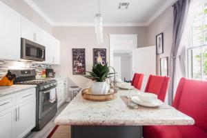 a kitchen with a table with red chairs in it at Shotgun Craftman House with Private Patio in New Orleans