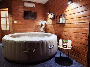 a large tub in a room with a wooden wall at "Oasis of Peace Zagreb-Apartments" in Zagreb