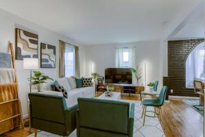 a living room with a couch and chairs and a tv at Beautiful - 4bd with Contemporary Interior in Lincoln
