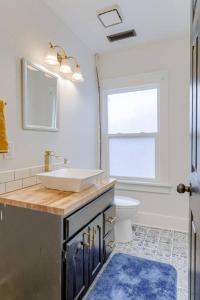 a bathroom with a sink and a toilet and a window at Beautiful - 4bd with Contemporary Interior in Lincoln +35 photos