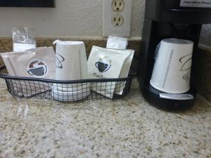 a basket of coffee cups sitting next to a coffee maker at Red Roof Inn Atlanta Airport NE Conley in Conley