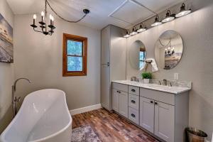 a bathroom with a tub and a sink and a mirror at Quaint home in the Pines in Flagstaff