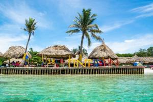 ein Resort mit einem Spielplatz und einigen Palmen und Wasser in der Unterkunft Hostal del Mar - Tolu in Tolú