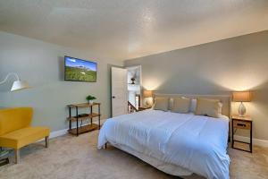 a bedroom with a large white bed and a yellow chair at Quaint home in the Pines in Flagstaff