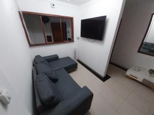 a living room with a couch and a flat screen tv at Hotel Vip Comfort Santa Marta in Santa Marta