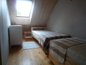 two beds in a room with a window at Namelis Palangoje in Palanga
