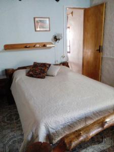 a bedroom with a bed and a wooden door at Lo de Fabi in La Coronilla
