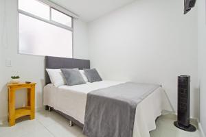 um quarto branco com uma cama e uma janela em Sabaneta Central Nómadas digitales Wi-Fi 401 em Sabaneta