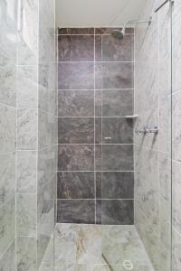 uma casa de banho com um chuveiro e uma porta de vidro em Sabaneta Central Nómadas digitales Wi-Fi 401 em Sabaneta