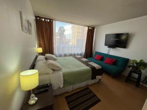 1 dormitorio con cama, sofá y TV en Apartment Relocation San Isidro, en Santiago