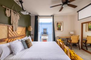 a bedroom with a large bed and a table at Selina Oaxaca in Oaxaca City