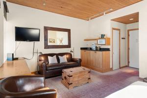 a living room with a couch and a tv at Independence Square Unit 313, Downtown Hotel Room in Aspen with Rooftop Hot Tub in Aspen