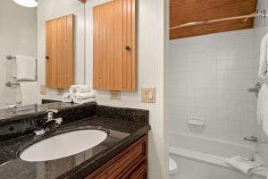 a bathroom with a sink and a toilet and a tub at Independence Square Unit 313, Downtown Hotel Room in Aspen with Rooftop Hot Tub in Aspen