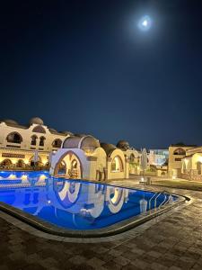 een uitzicht op een gebouw met een zwembad in de nacht bij Elphardous Oasis Hotel in Luxor