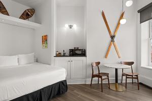 阿斯潘Independence Square 202, Hotel Room Over-looking the Mall and Aspen Mountain的一间卧室，配有一张床、一张桌子和几把椅子