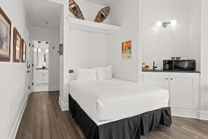 a white bedroom with a bed and a microwave at Independence Square 202, Hotel Room Over-looking the Mall and Aspen Mountain in Aspen