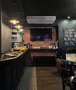 a bar in a restaurant with a brick wall at The Wellington Hotel Birmingham - Breakfast Included City Centre Near O2 Academy in Birmingham