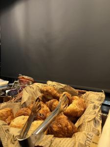 a basket of bread and croissants on a table at The Wellington Hotel Birmingham - Breakfast Included City Centre Near O2 Academy in Birmingham