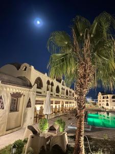 a palm tree in front of a building at night at Elphardous Oasis Hotel in Luxor