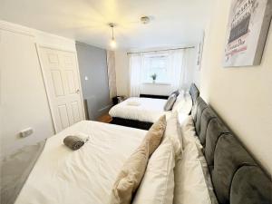 a small bedroom with two beds and a window at Beautiful Modern Apt (Sleeps 5) in Croydon