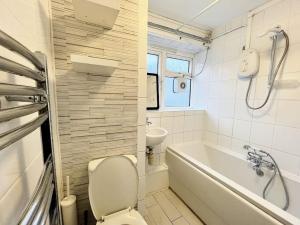 uma casa de banho com um WC, uma banheira e um lavatório. em Beautiful Modern Apt (Sleeps 5) em Croydon