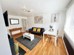 uma sala de estar com um sofá e uma mesa em Beautiful Modern Apt (Sleeps 5) em Croydon