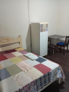 1 dormitorio con 1 cama y nevera en Cortiço da Lapa, en Río de Janeiro