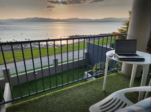 a laptop on a table on a balcony overlooking the beach at Boulevard Waters in Taupo