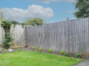 a wooden fence in a yard next to at The Dunstable House in Houghton Regis