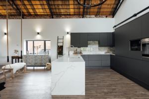 a kitchen with black cabinets and a white counter top at Herts Haven, Luxury 2 Bedroom En Suite Barn With Beautiful Views, Free Parking, PS5 & More! in Hemel Hempstead +27 photos