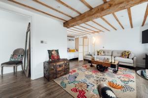 a living room with a couch and a table at Herts Haven, Luxury 2 Bedroom En Suite Barn With Beautiful Views, Free Parking, PS5 & More! in Hemel Hempstead