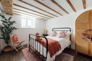 een slaapkamer met een bed en een stoel bij Herts Haven, Luxury 2 Bedroom En Suite Barn With Beautiful Views, Free Parking, PS5 & More! in Hemel Hempstead