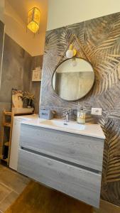 een badkamer met een wastafel en een spiegel bij Koru House Torvaianica in Torvaianica