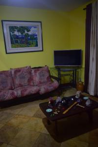 ein Wohnzimmer mit einem Sofa und einem Tisch in der Unterkunft Casa Verde do Peró in Cabo Frio