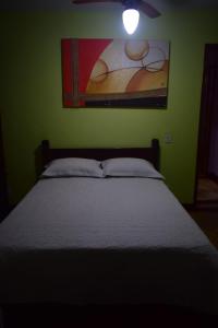 Schlafzimmer mit einem Bett mit Wandgemälde in der Unterkunft Casa Verde do Peró in Cabo Frio