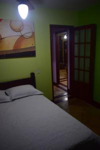 ein Schlafzimmer mit einem Bett und einem Wandgemälde in der Unterkunft Casa Verde do Peró in Cabo Frio