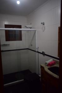 ein Bad mit einer Dusche und einem Waschbecken in der Unterkunft Casa Verde do Peró in Cabo Frio