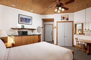 a bedroom with a bed and a table and a kitchen at Independence Square 311, Best Location! Hotel Room with Rooftop Hot Tub in Aspen in Aspen