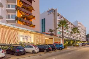 a row of cars parked in front of a building at Higuerón Hotel Curio Collection by Hilton in Fuengirola