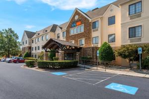 eine Einrichtung an der Vorderseite eines Hotels mit einem Parkplatz in der Unterkunft Sonesta ES Suites Charlotte Arrowood in Charlotte