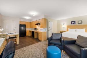 a hotel room with a bed and a kitchen at Sonesta ES Suites Charlotte Arrowood in Charlotte