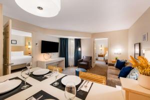 ein Hotelzimmer mit einem Esstisch und einem Wohnzimmer in der Unterkunft Sonesta ES Suites Charlotte Arrowood in Charlotte