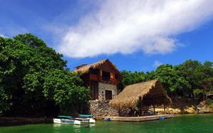 uma casa na costa de um corpo de água em Isla Única em Isla Grande