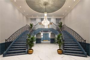 a lobby with stairs and a chandelier at DoubleTree By Hilton Brighton Metropole in Brighton & Hove