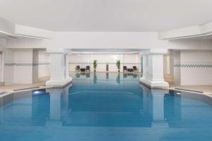 a large swimming pool with columns in a building at DoubleTree By Hilton Brighton Metropole in Brighton & Hove
