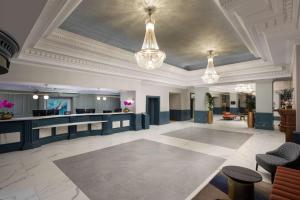 a lobby with two chandeliers and a reception desk at DoubleTree By Hilton Brighton Metropole in Brighton & Hove